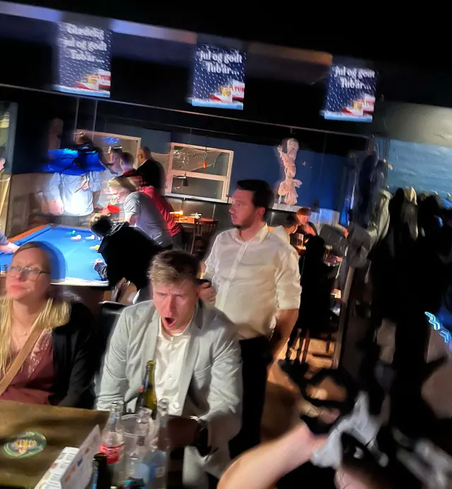 Gæster ved bordene og poolbordet under julepynten på Oxen